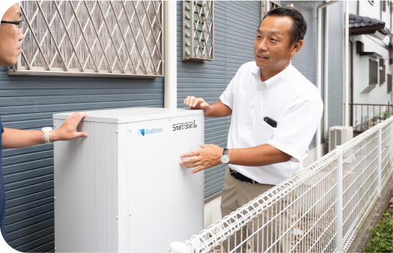 スタッフが顧客と蓄電池を見ながら話している様子
